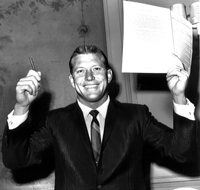 Mickey Mantle holds up his pen and the contract he signed with the New York Yankees for the 1962 season.